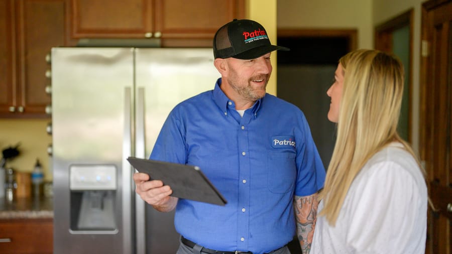 Patriot Plumbing technician explaining drain cleaning recommendations to a homeowner in Wenatchee.