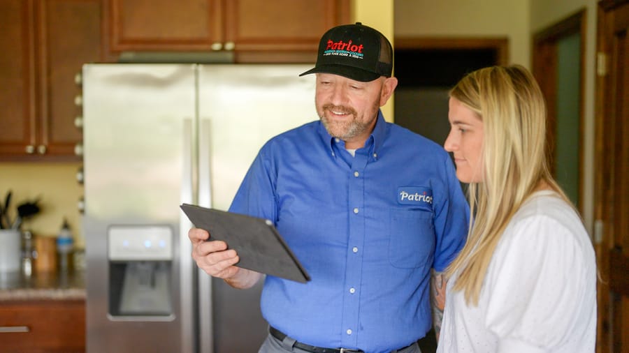 Patriot Plumbing technician reviewing completed repiping work and system details with a homeowner in Wenatchee.