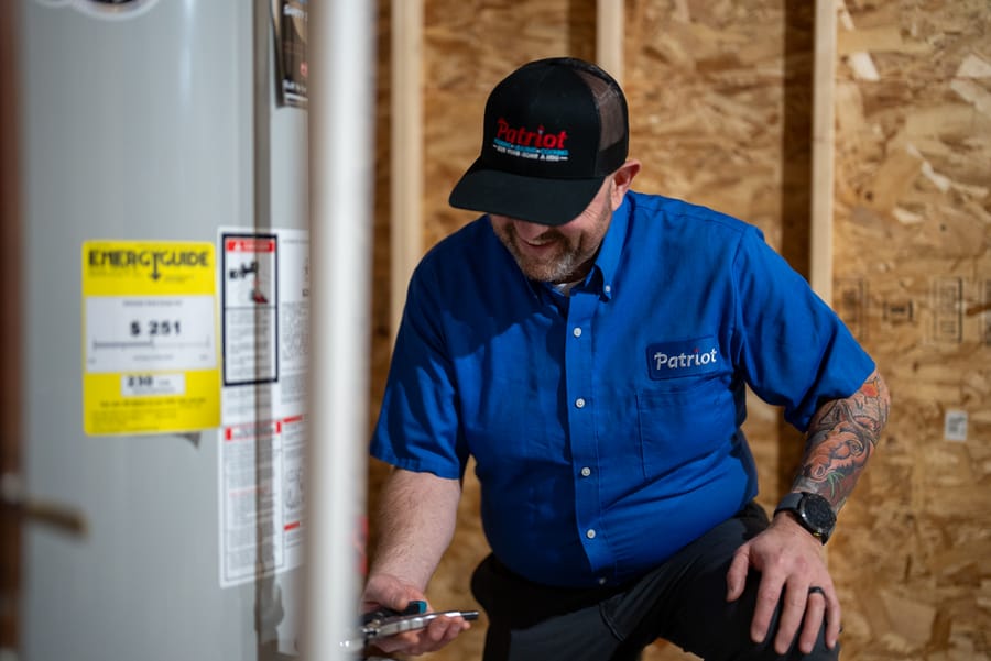 Licensed Patriot Plumbing technician performing water heater service in a Wenatchee home.